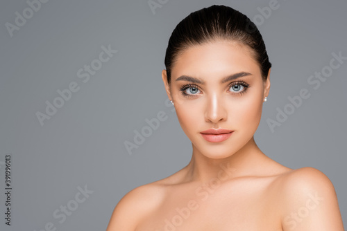 beautiful woman posing isolated on grey © LIGHTFIELD STUDIOS