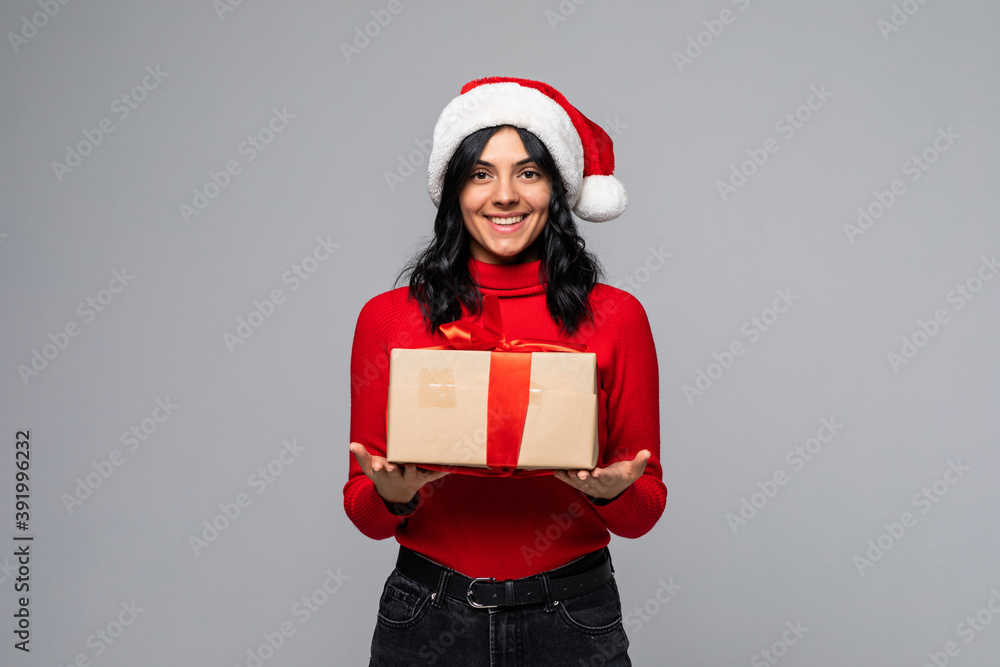 Christmas woman received a gift isolated on gray background. Santa hat isolated portrait of a woman on a gray background. Christmas woman received a gift isolated on gray background. Santa hat isolated portrait of a woman on a gray background.