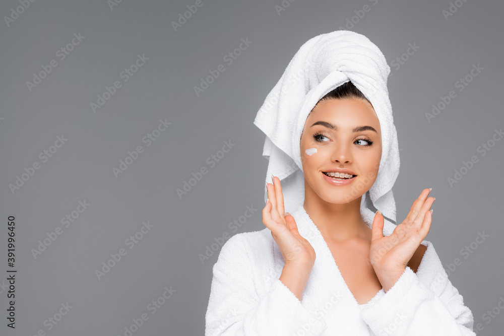smiling woman with towel on head and cosmetic cream on face isolated on grey smiling woman with towel on head and cosmetic cream on face isolated on grey