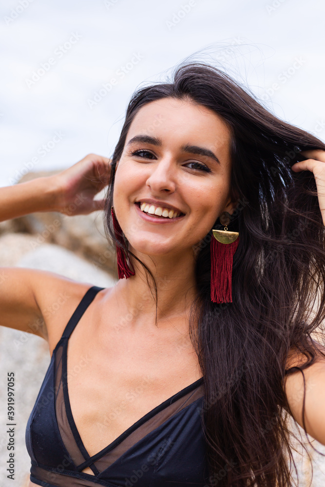 Portrait of happy slim stylish woman on rocky beach at sunset Portrait of happy slim stylish woman on rocky beach at sunset