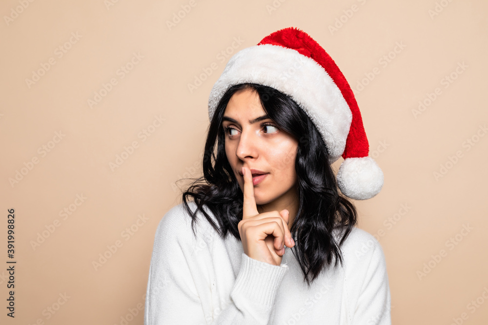 Young woman doing silence gesture with christmas hat over isolated background Young woman doing silence gesture with christmas hat over isolated background