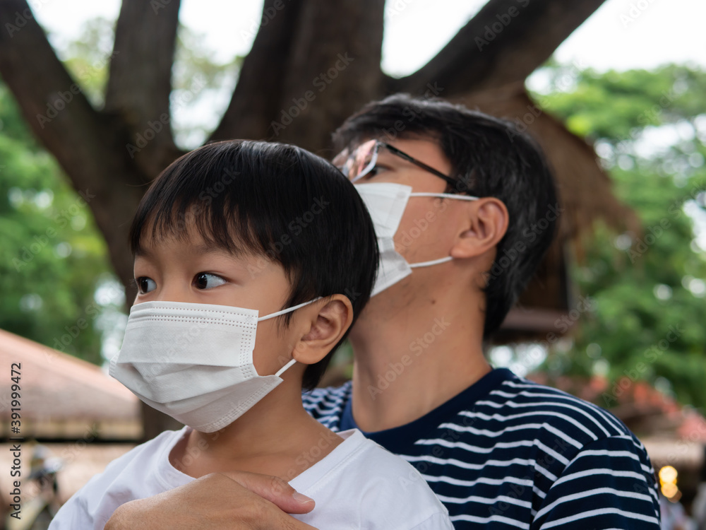 Asian cute child boy and father travel outdoor in holiday with wearing white face mask for protect covid 19. Health care concept.