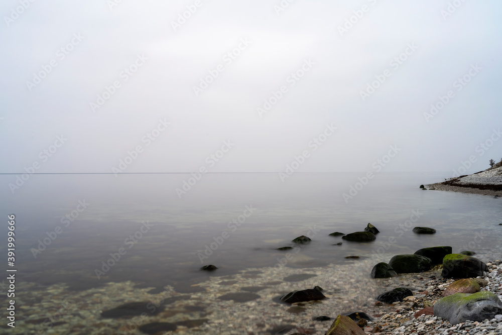 Fog rolling in from the ocean over coastal landscape on the island of Gotland in Sweden