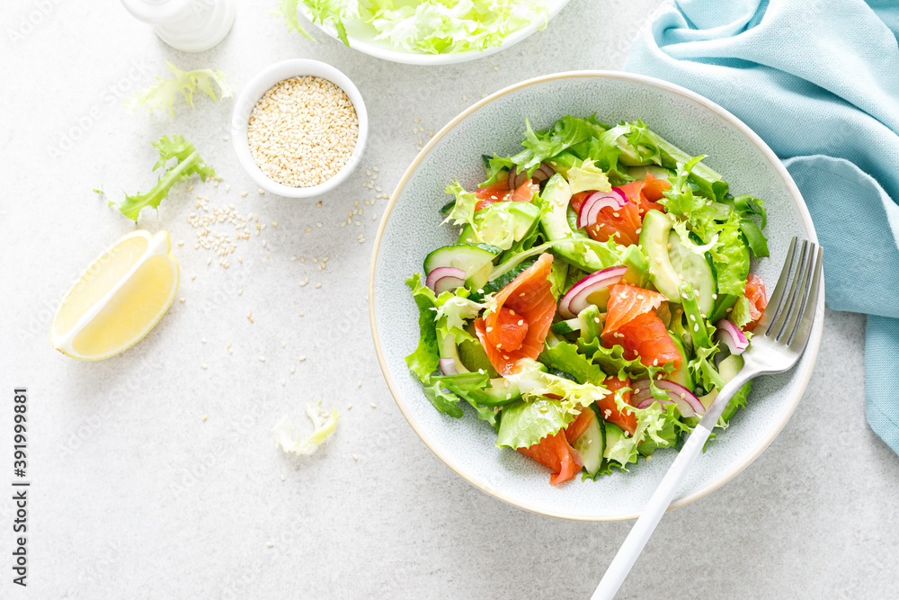 Salmon avocado salad with salted fish, lettuce, red onion and cucumbers Salmon avocado salad with salted fish, lettuce, red onion and cucumbers