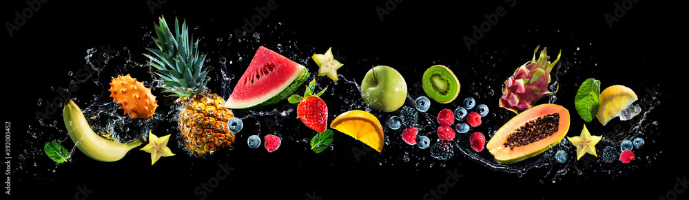 Assortment of fresh fruits and water splashes on panoramic background