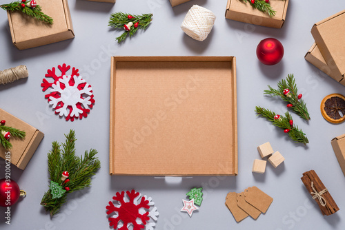 Mock up cardboard box decorated with Christmas tree ornament on grey background