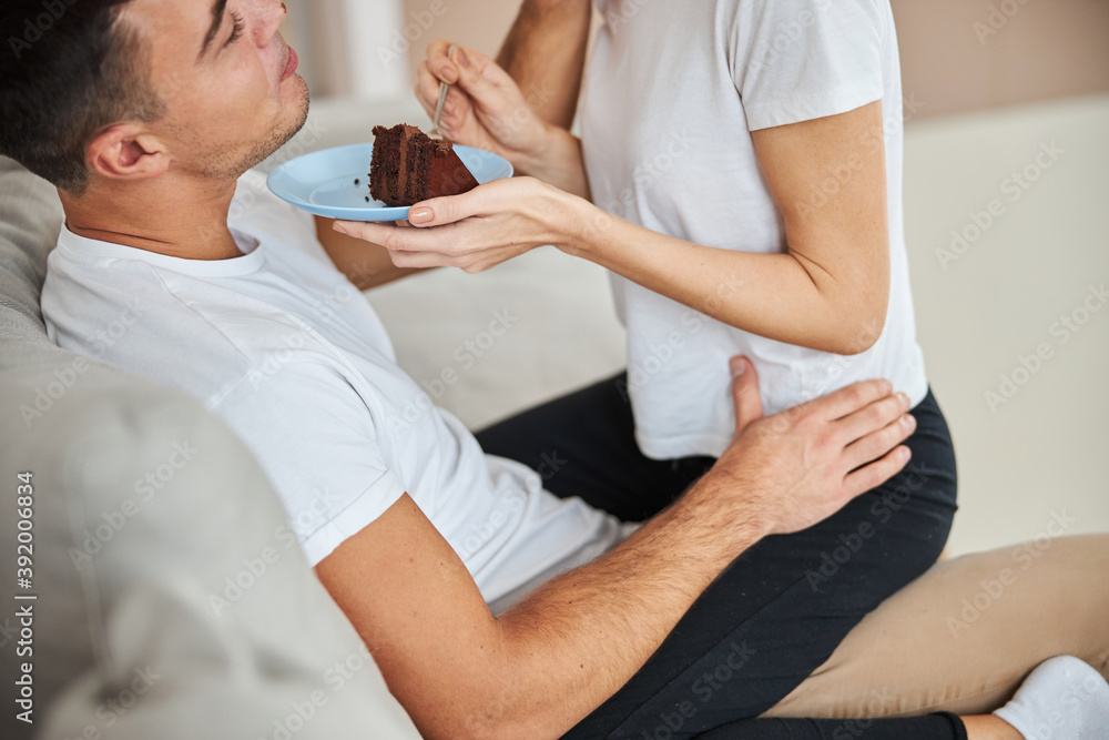 Fototapeta premium Relaxed man eating chocolate cake with his girlfiend