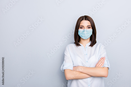 Photo portrait of girl with crossed arms wearing blue face mask isolated on white colored background with blank space