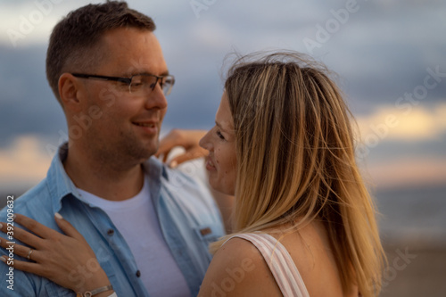 a portrait of happy couple. A woman put hands on man's shoulders who is holding her hands. Honeymoon concept © Yulia Raneva