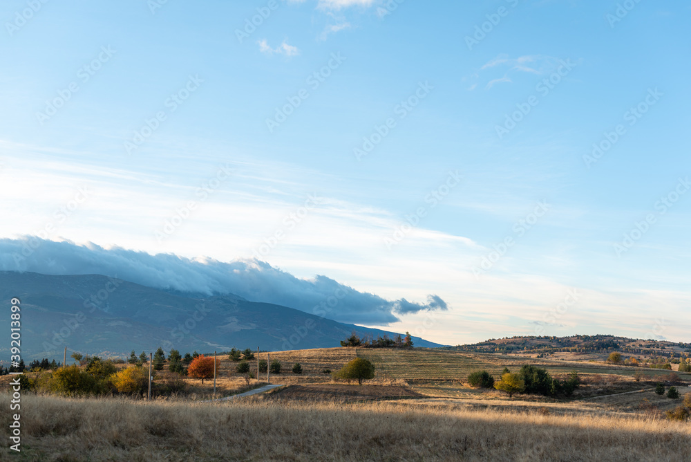 Obraz premium Autumn landscape golden hillside sunny day with storm approaching from left side in rural Bulgaria