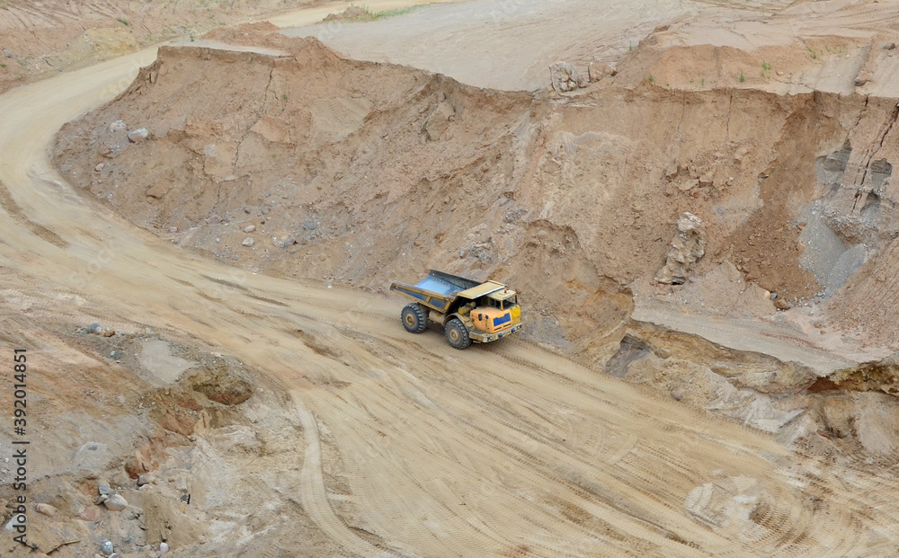 Mining truck transports sand in an open pit. View of the quarry where
