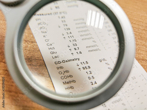 Results of arterial blood gas analysis examined under magnifying glass.
