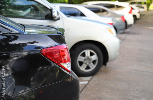 Closeup of rear side of black car and other cars parking in parking area. © Amphon