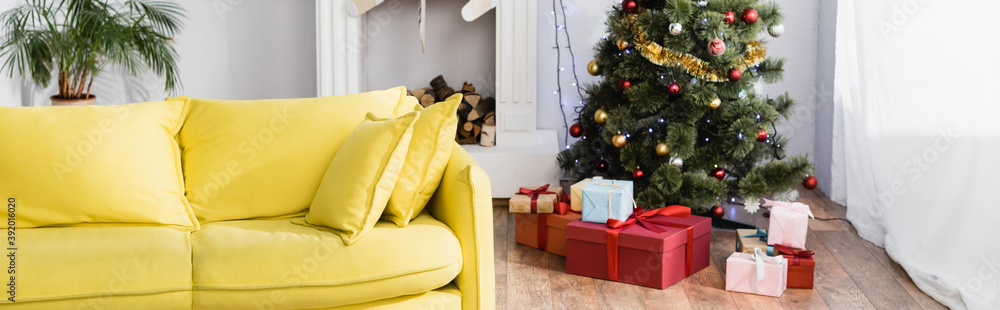 wrapped presents under christmas tree in decorated and modern living room, banner