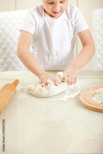 baby knead the dough in flour © skif