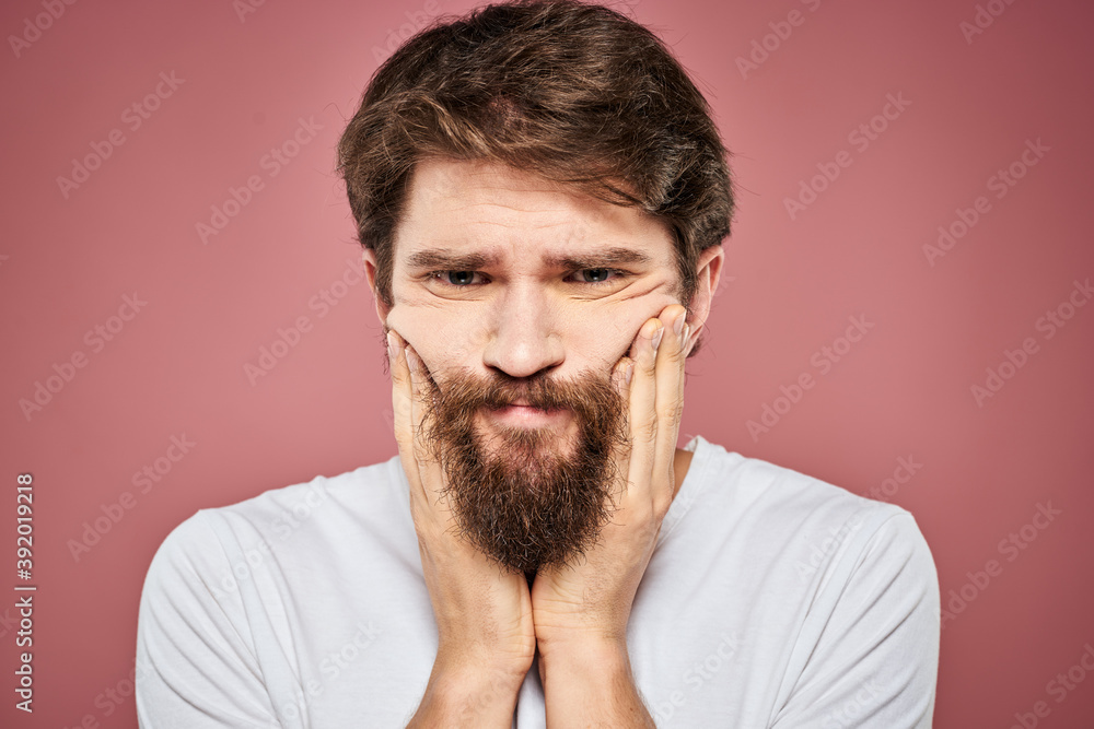 emotional man white t shirt sad facial expression pink background