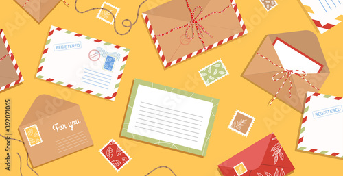 Envelope, letters, stamps and postcards on the table. Workspace with flat style postage elements. Background with greeting cards and blank hand drawn.