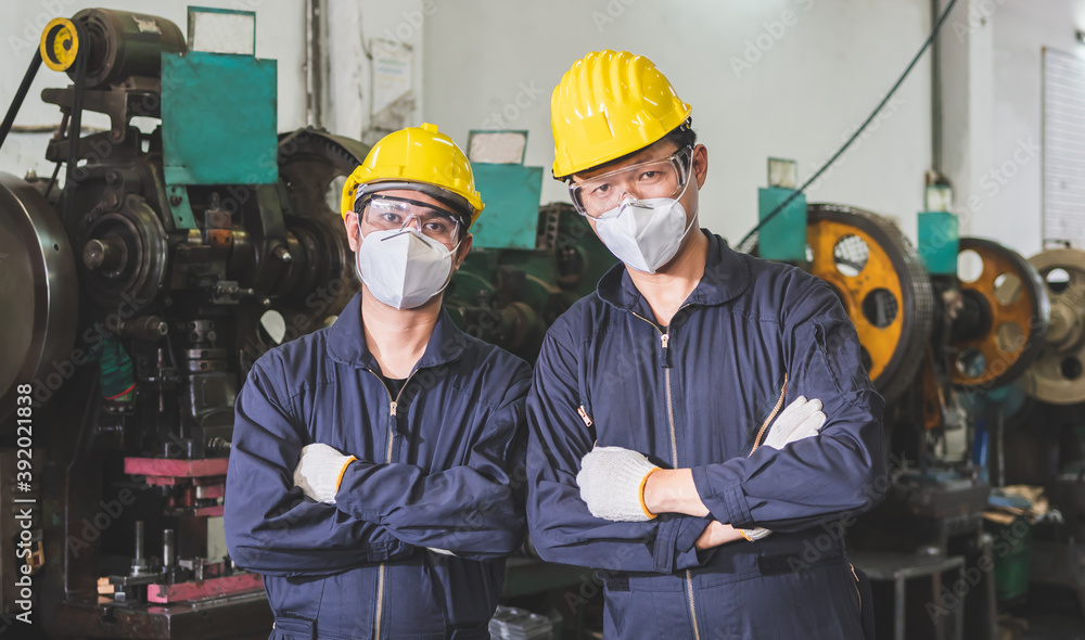 Workers in uniforms crossed arms in the factory. Workers in uniforms crossed arms in the factory.