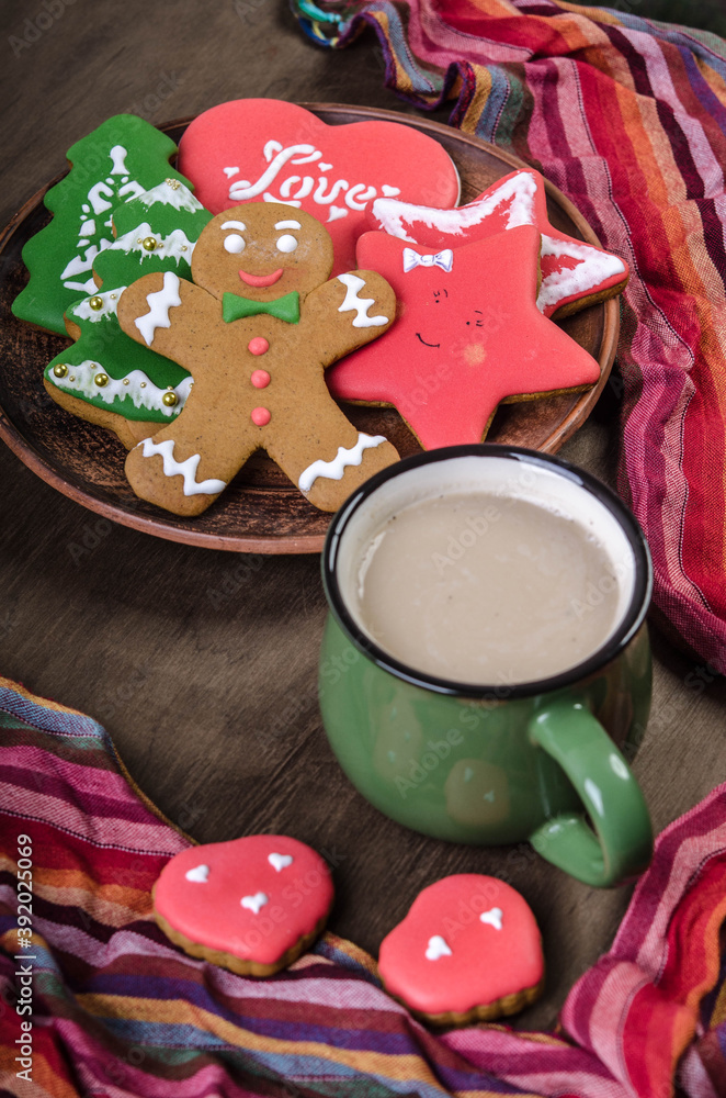 Multicolored Christmas gingerbread cookies and cocoa on a dark background