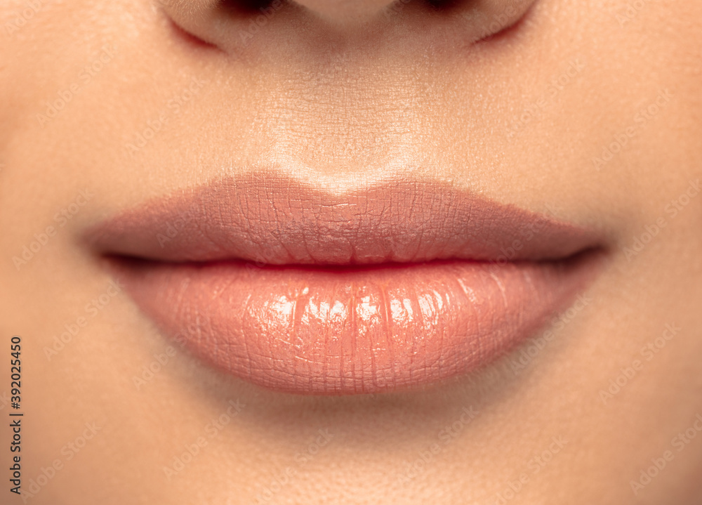 Fototapeta premium Lips. Close up portrait of beautiful young woman on studio background. Concept of cosmetics, makeup, natural and eco treatment, skin care. Shiny and healthy look, fashion, healthcare. Details.