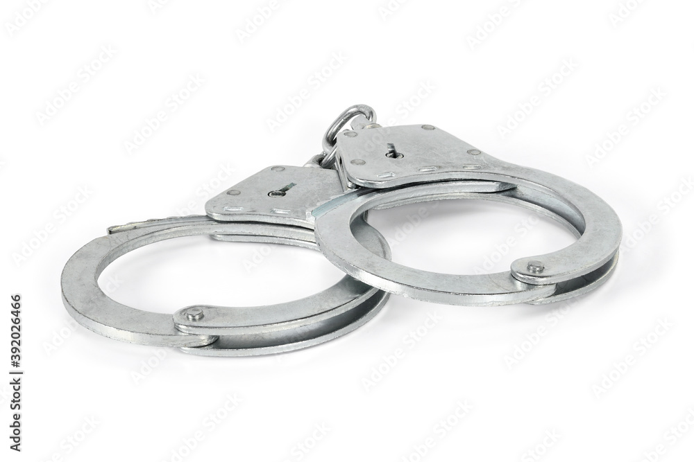 Handcuffs isolated on white background with light shadows. Pair of silver handcuffs macro close-up high resolution.
