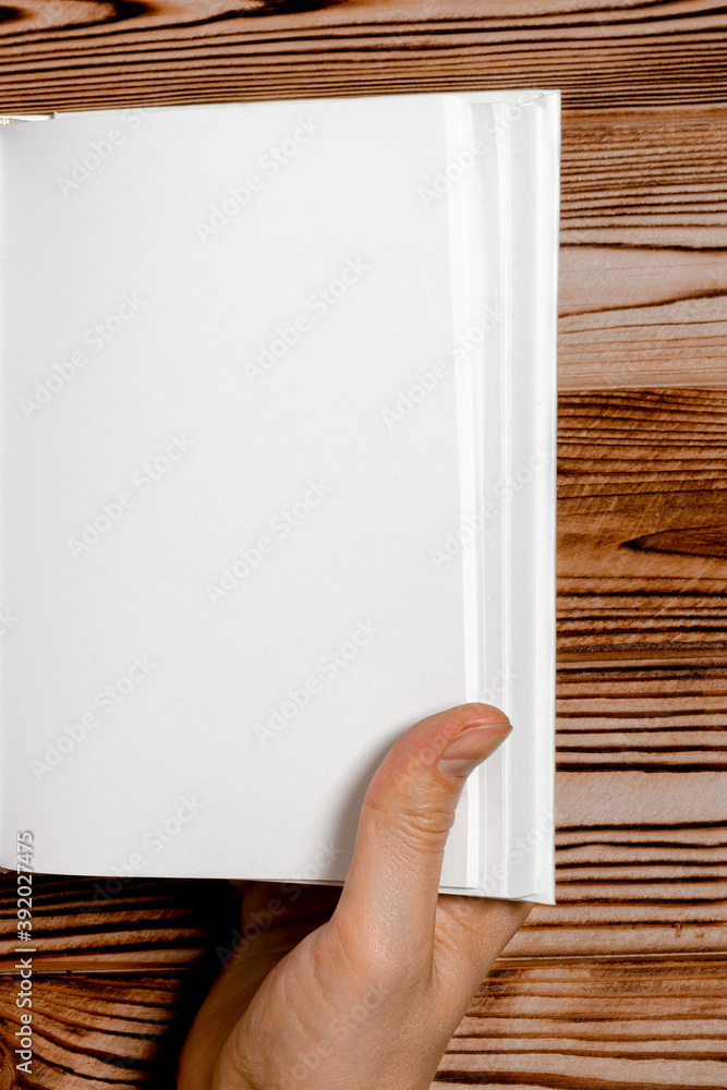Men's hands holding open book with blank cover on light background Men's hands holding open book with blank cover on light background
