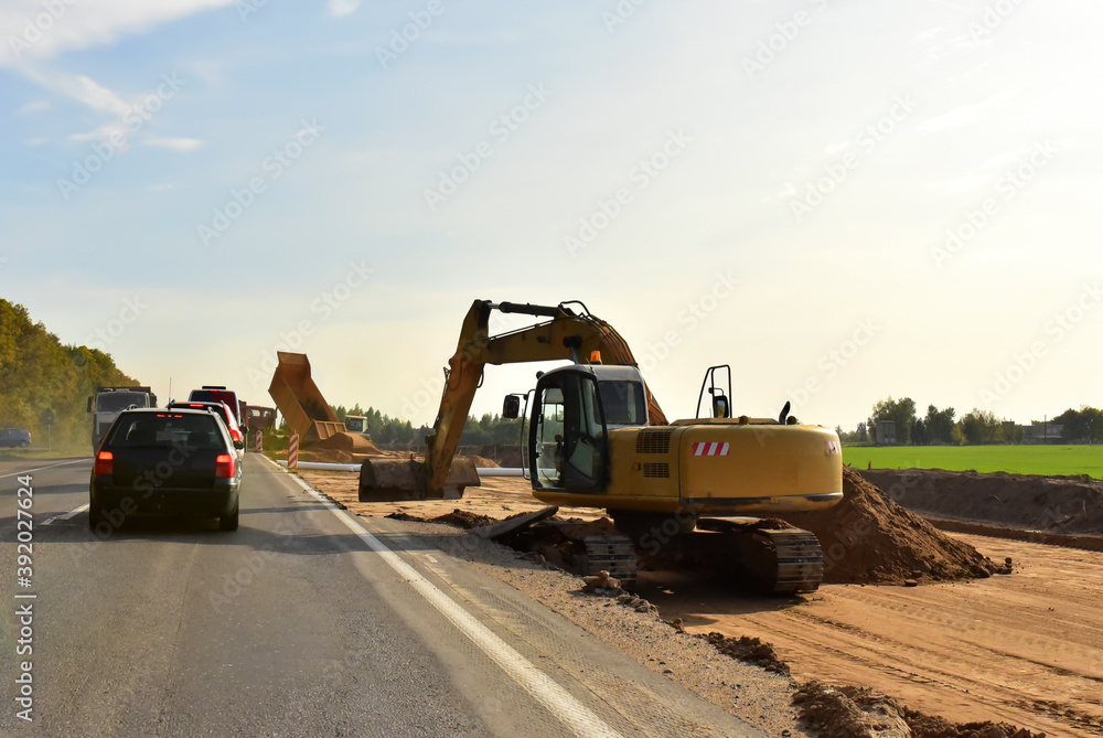 Excavator On Earthworks and Road Construction in City. Temporary Traffic Regulation from carrying out road works or activity on the public highway. Roadway Work Zone Safety. Out of focus, motion blur