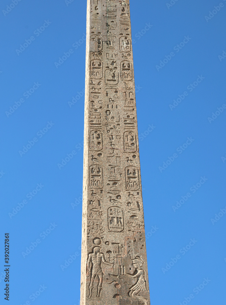 ancient egyptian obelisk with many engraved hieroglyphs and sky