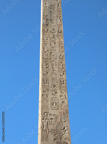Fototapeta ancient egyptian obelisk with many engraved hieroglyphs and sky