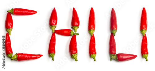 Word chili made up of fresh red peppers on white background