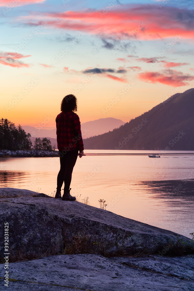 Girl Watching a Peaceful Sunrise on the Ocean Coast. Located in Saltery Bay, Sunshine Coast, British Columbia, Canada. Dramatic Colorful Sky Art Render