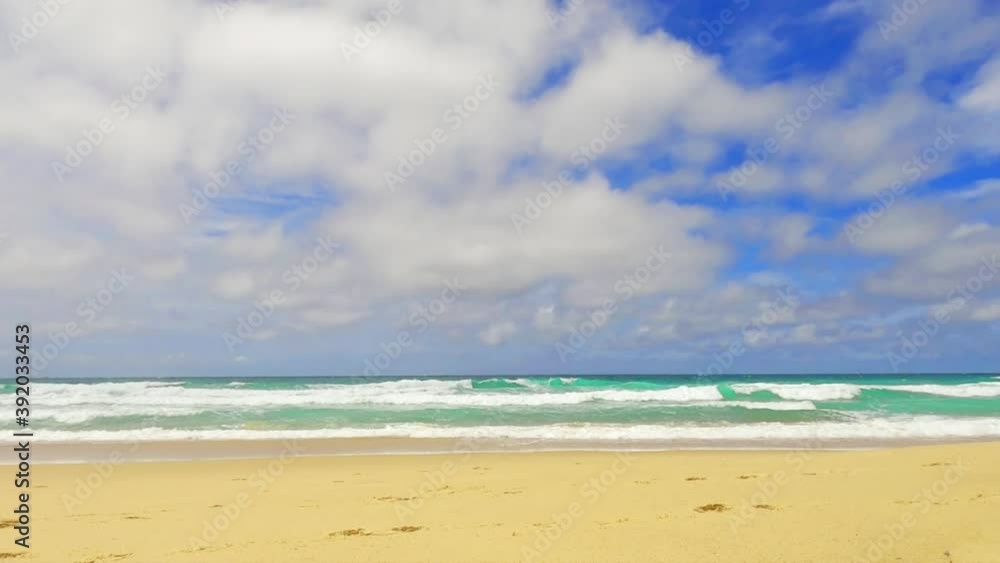Panorama view of Beautiful cyan sea water surface & exotic ocean wave reaching golden yellow sandy beach on sunny blue sky with white puffy fluffy cloud & cloudscape in tropical summer sunlight rays Panorama view of Beautiful cyan sea water surface & exotic ocean wave reaching golden yellow sandy beach on sunny blue sky with white puffy fluffy cloud & cloudscape in tropical summer sunlight rays