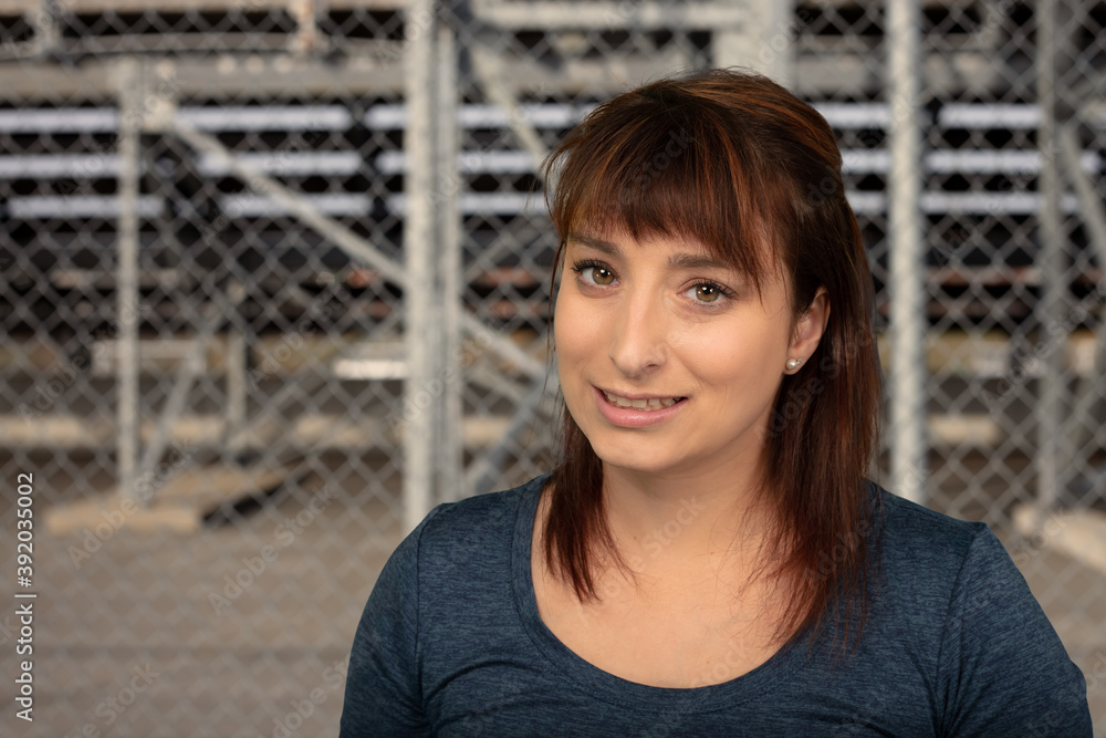 Fototapeta premium woman smiling outside in the city park playground fence background