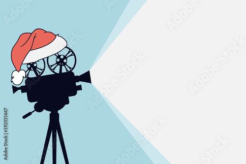 Silhouette of vintage cinema projector on a tripod with Santa Claus hat. Cinema background. Film camera projecting a beam of light with place for text. Movie festival template for banner, flyer,poster