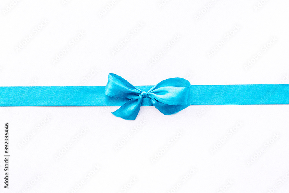 Blue ribbon with bow isolated on white for gift box. Top view, copy space