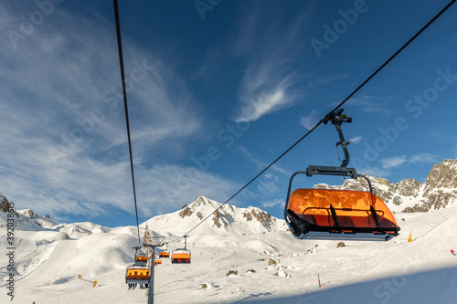 Scenic panoramic view of Silvretta ski area at Iscgl and Samnaun skiing resort with chairlifts , downhill slpoes and clear blue sky on background. Winter sport travel recreation and activities