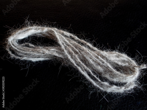 tiny skein of handspun cat wool on a black background