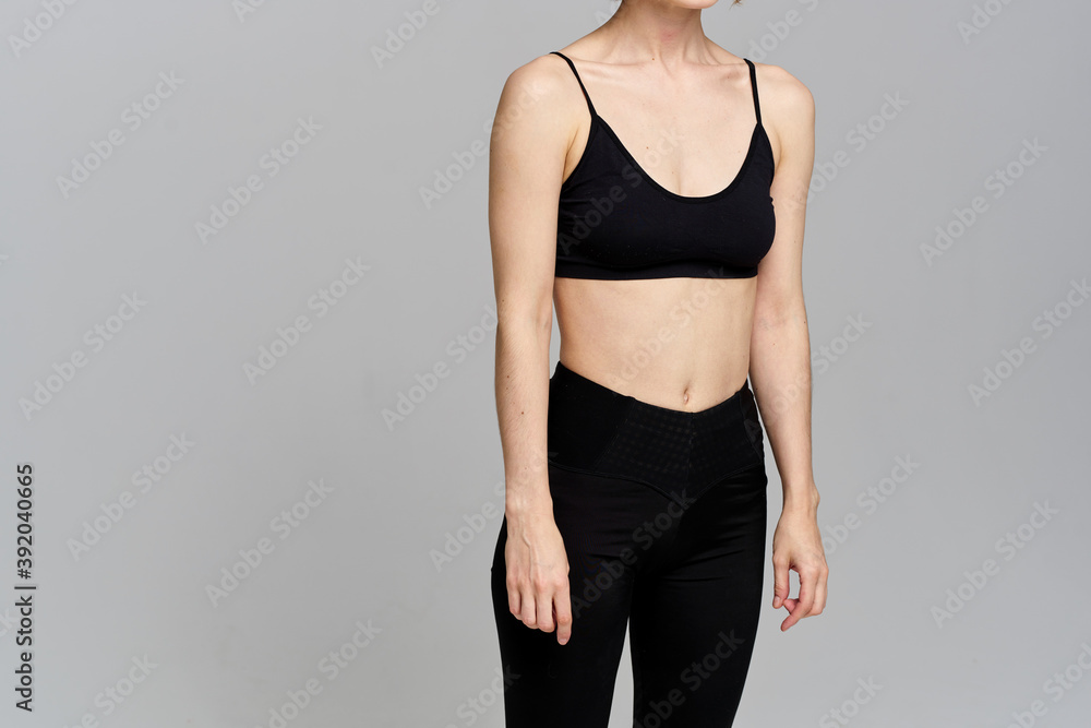 Sporty woman in leggings on a gray background is engaged in fitness Copy Space Sporty woman in leggings on a gray background is engaged in fitness Copy Space