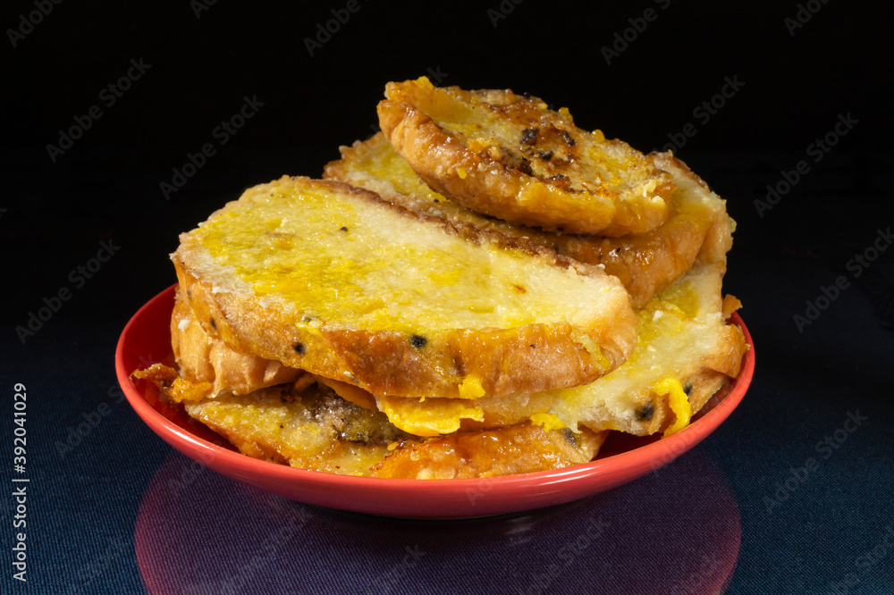 Roasted white bread in milt with egg on red plate Roasted white bread in milt with egg on red plate