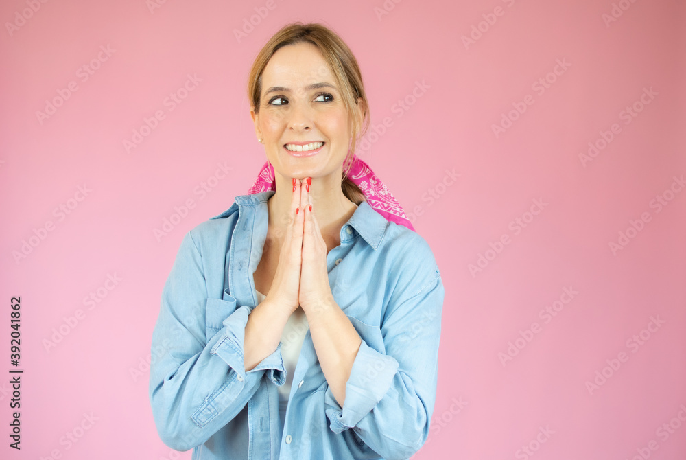 Close up shot of stylish young woman in denim shirt smiling against pink background. Beautiful female with copy space. Close up shot of stylish young woman in denim shirt smiling against pink background. Beautiful female with copy space.