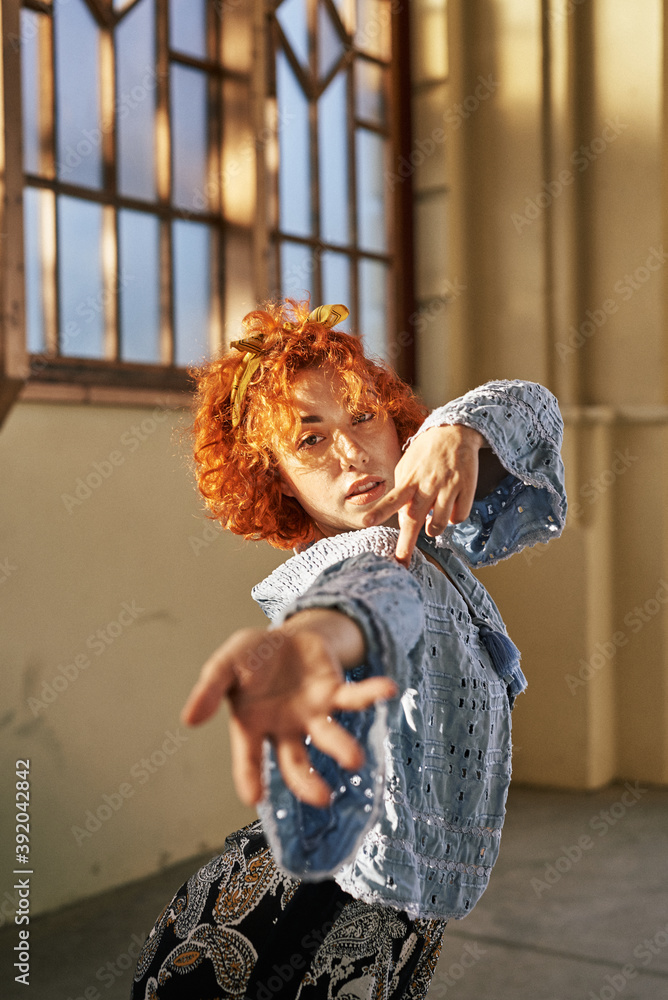 Young alternative redhead girl dancing in a blue blouse Young alternative redhead girl dancing in a blue blouse