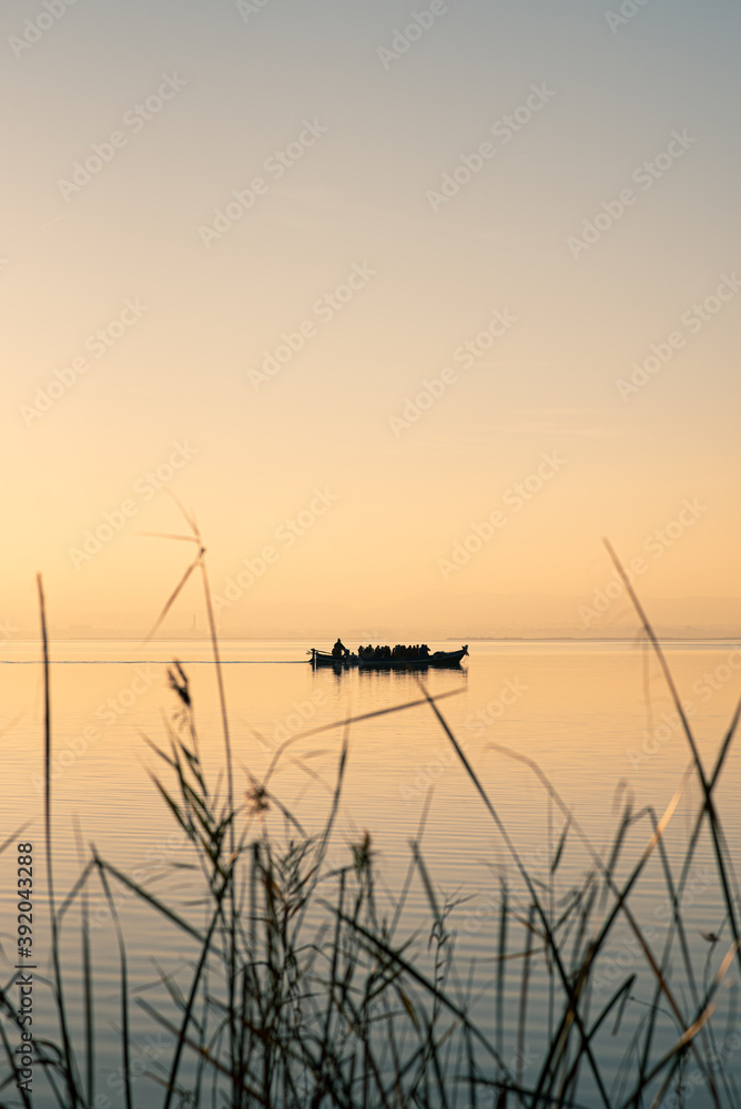 Boat in Valencia's Albufera at sunset against the light Boat in Valencia's Albufera at sunset against the light