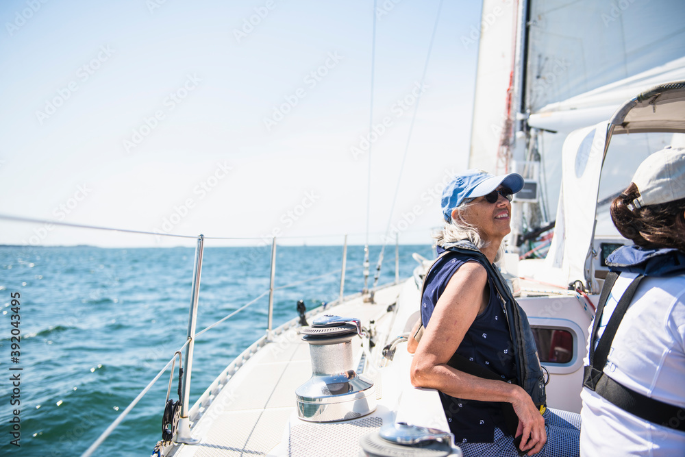 Middle aged woman enjoying family sail on sunny summer day Middle aged woman enjoying family sail on sunny summer day
