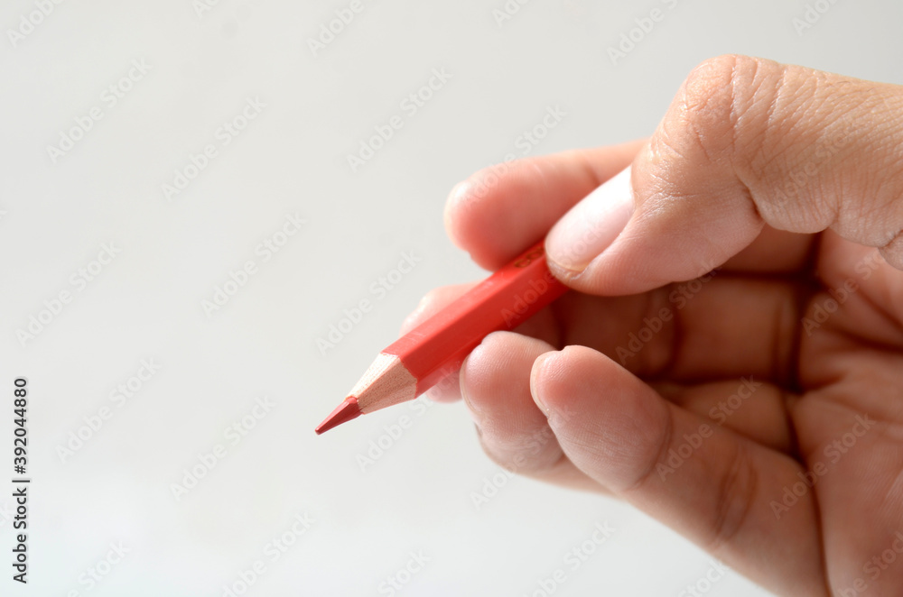 hand holding red color pencil hand holding red color pencil