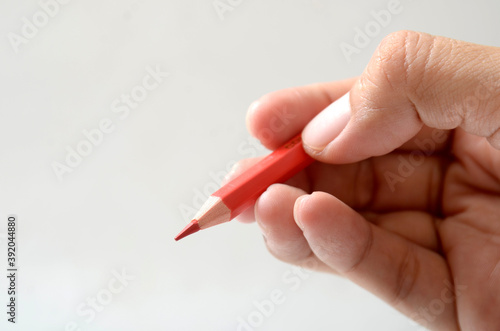 hand holding red color pencil