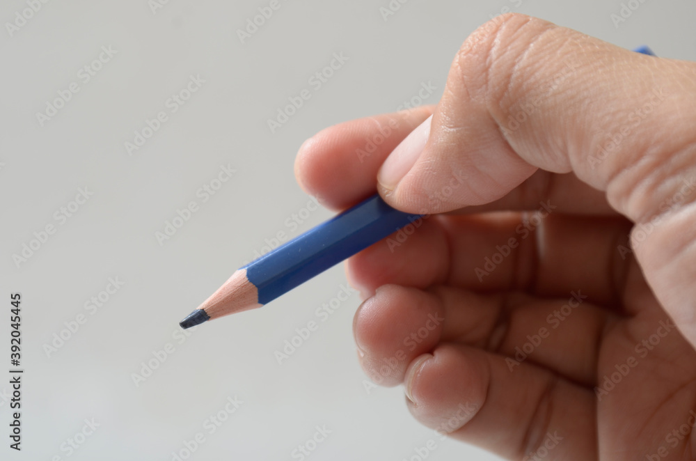 hand with blue color pencil hand with blue color pencil