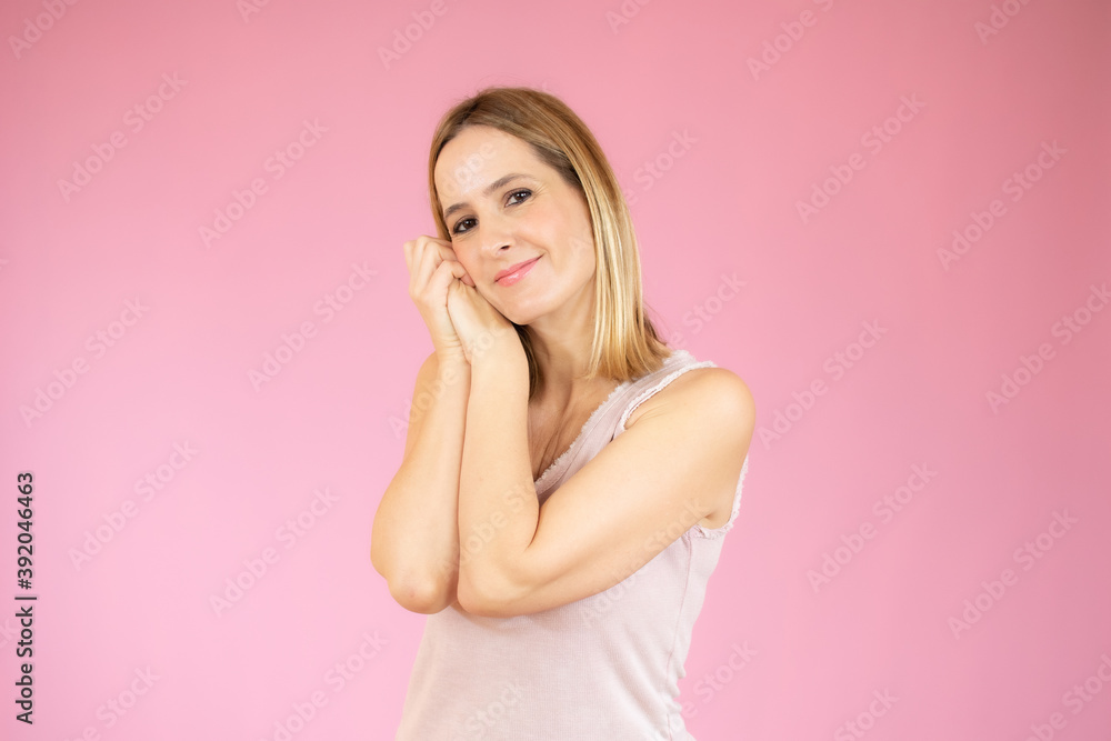 Young woman over isolated pink background making sleep gesture in adorable expression Young woman over isolated pink background making sleep gesture in adorable expression