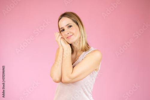 Young woman over isolated pink background making sleep gesture in adorable expression