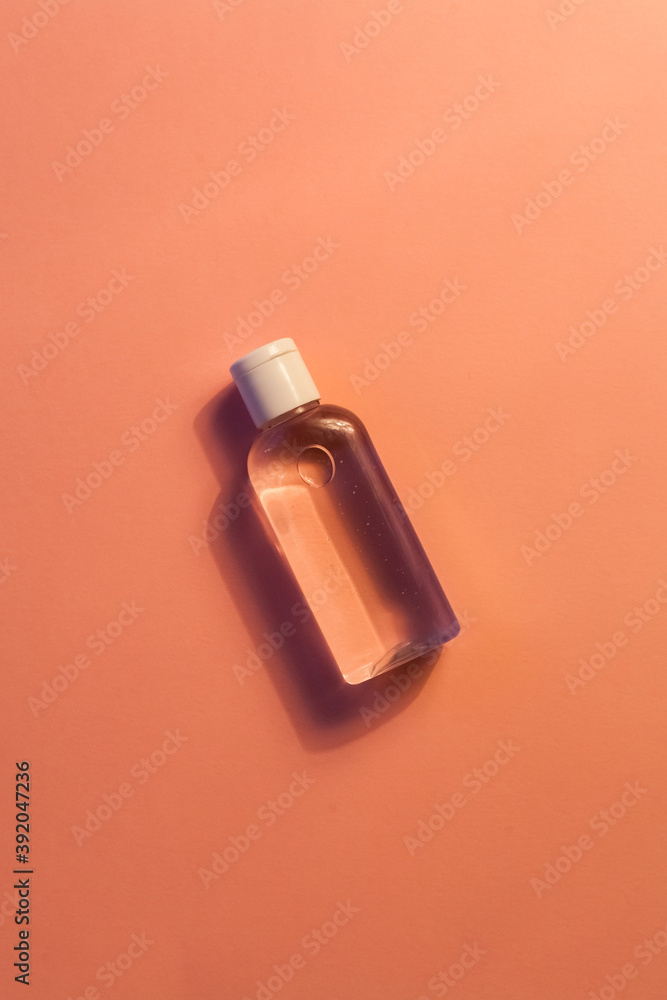 plastic clear transparent bottle without label with antiseptic shampoo shower gel lotion cleanser. yellow and pink flat background plastic clear transparent bottle without label with antiseptic shampoo shower gel lotion cleanser. yellow and pink flat background