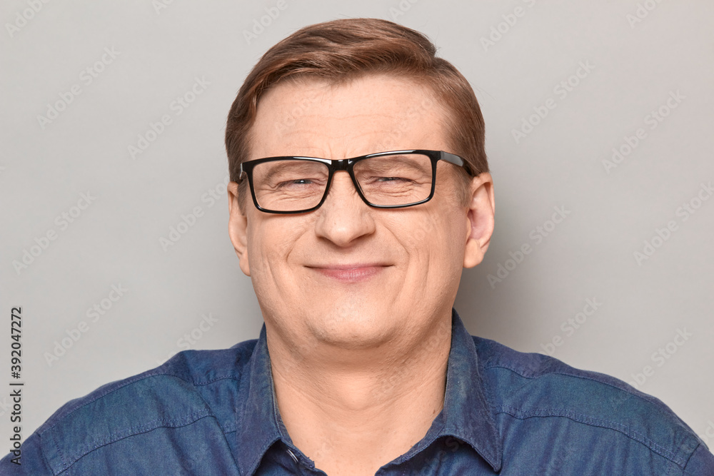 Portrait of happy optimistic man with glasses, smiling cheerfully